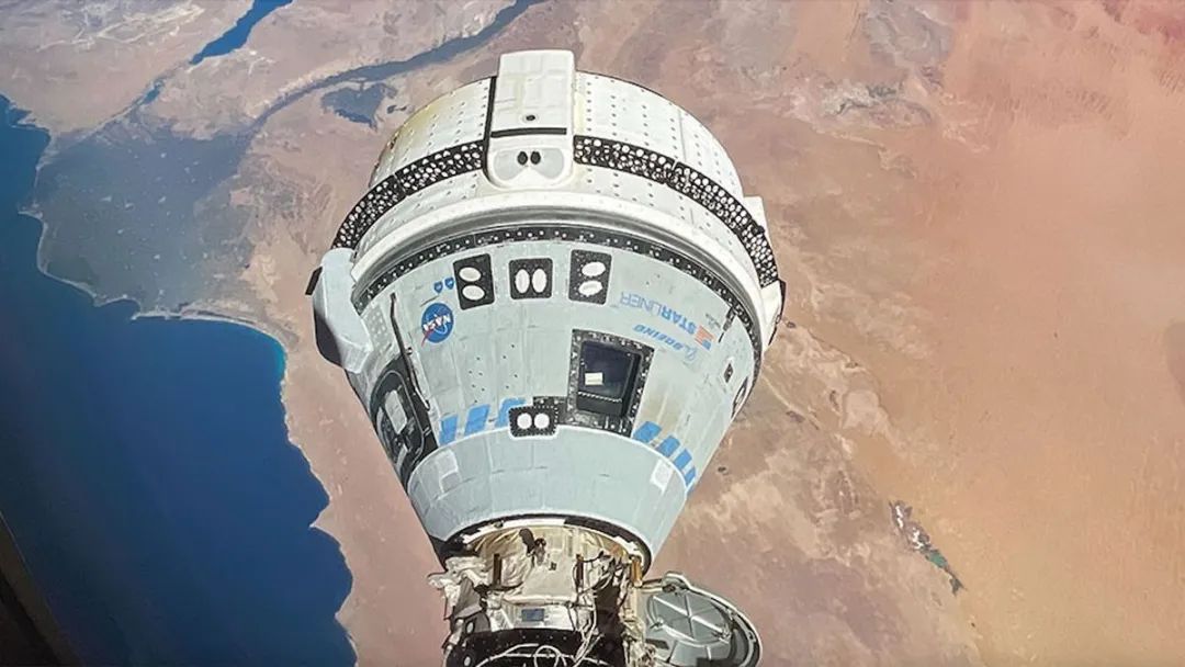 在地球上棕色的沙漠景观上空可以看到一个白色的太空舱